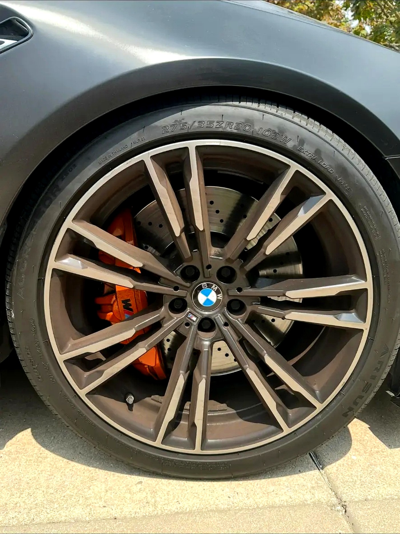 Polished BMW M wheel with orange brake calipers